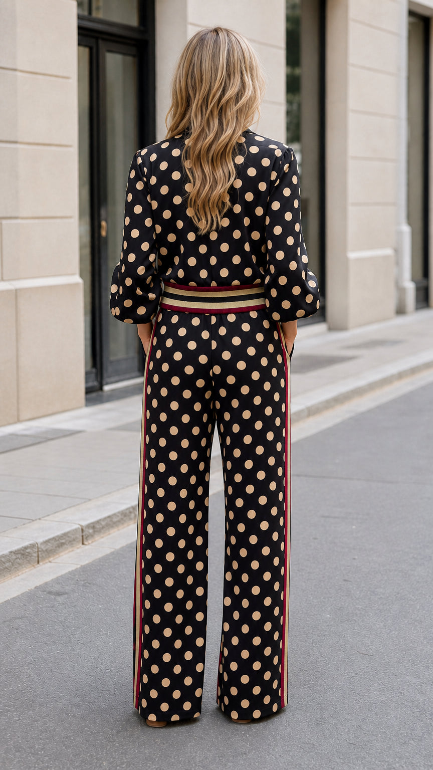 Back view of woman wearing black polka dot zip jacket and wide-leg pants