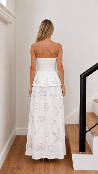 Back view of model in white strapless maxi dress