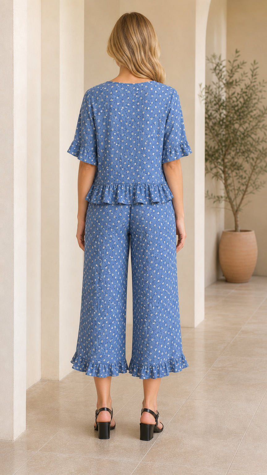 Back view of model wearing blue floral matching two-piece top and pants set
