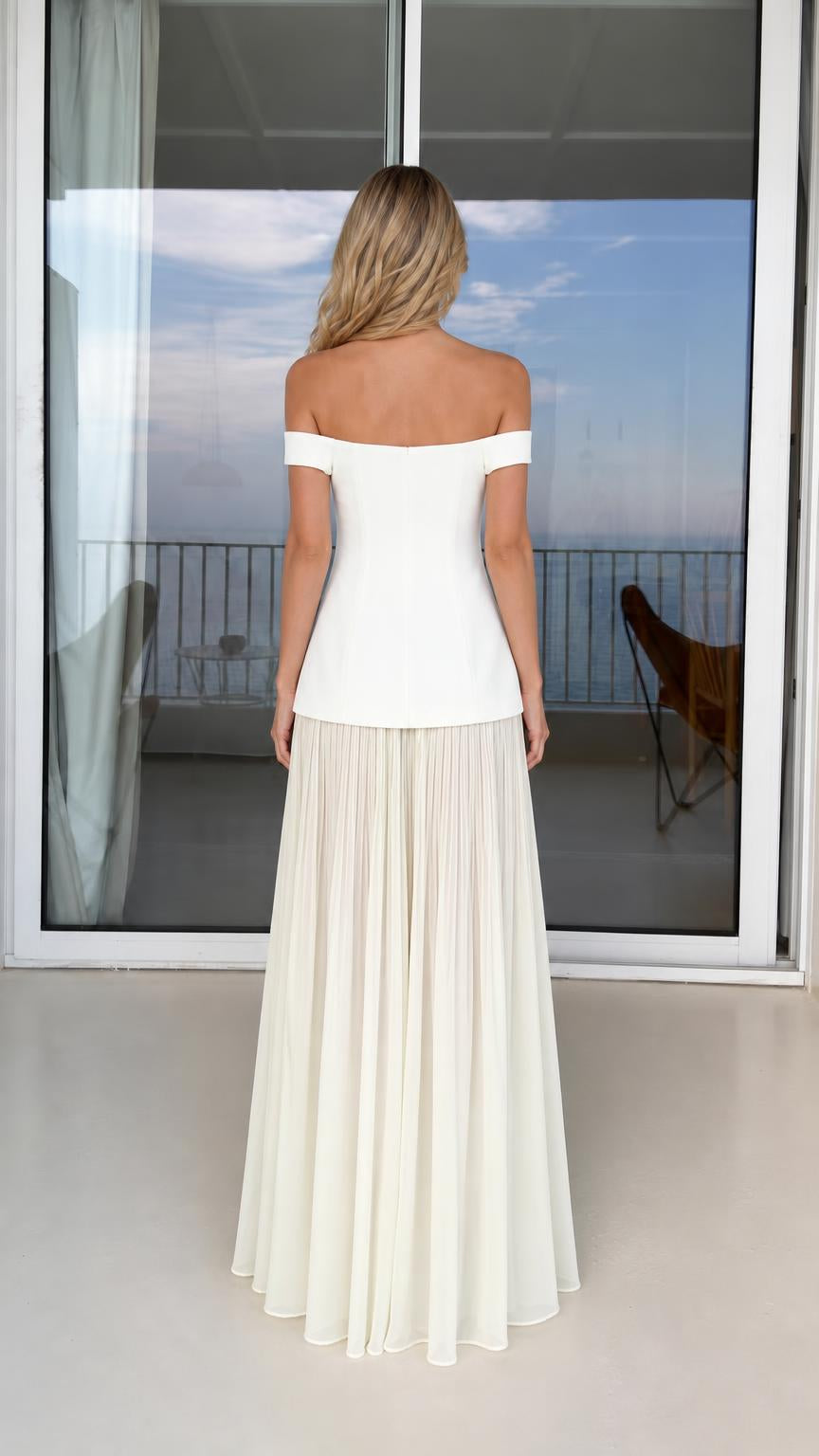 Back view of model in white off-shoulder top and maxi skirt