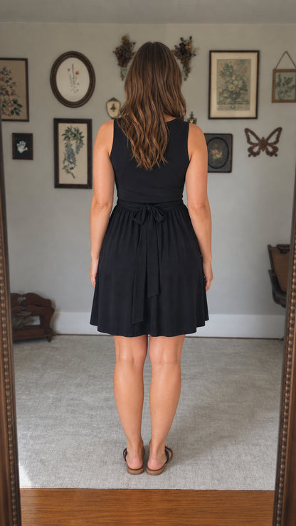 Back view showcasing back tie detail on black mini dress