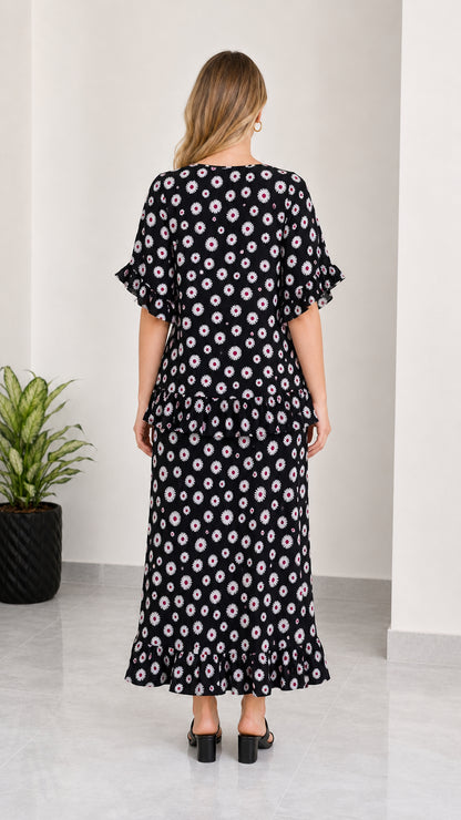 Back view of women's black daisy print two-piece ruffle maxi set