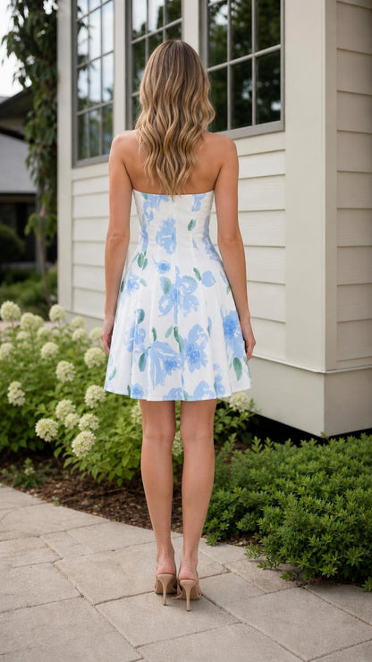 Back view of model wearing white floral strapless mini dress