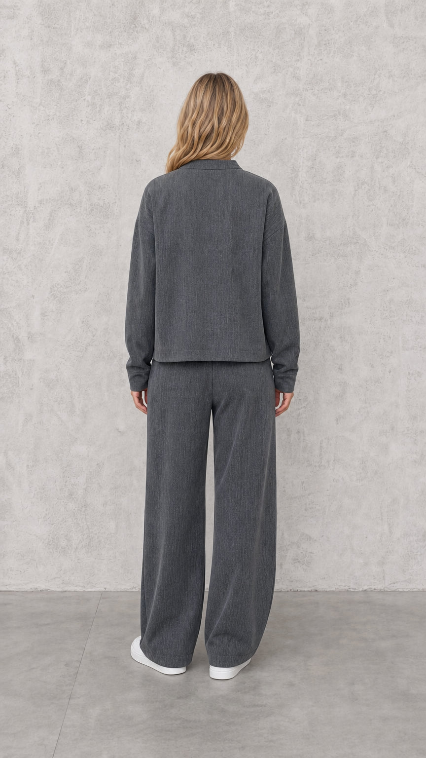 Back view of model wearing Charcoal Grey two-piece jacket and trouser set