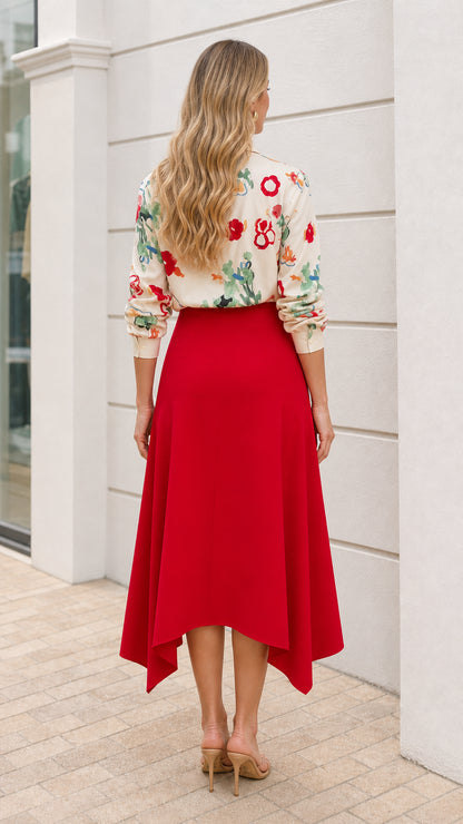 Model wearing cream floral button down shirt and red asymmetric midi skirt back view
