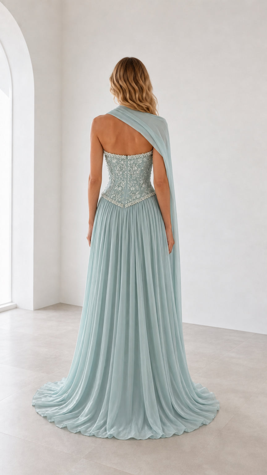 Back view of sage green evening gown showcasing draped cape and train