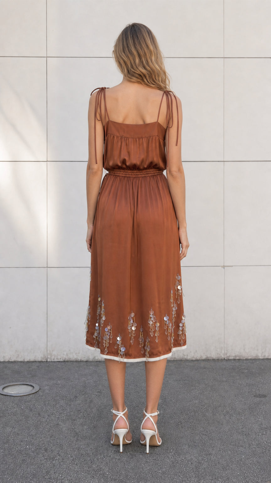 Back view of model wearing brown satin embellished midi slip dress