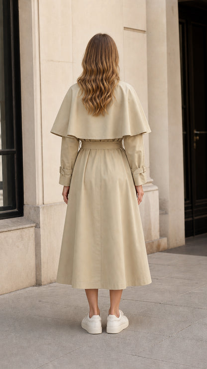Back view of woman showing the capelet design on a beige midi trench coat