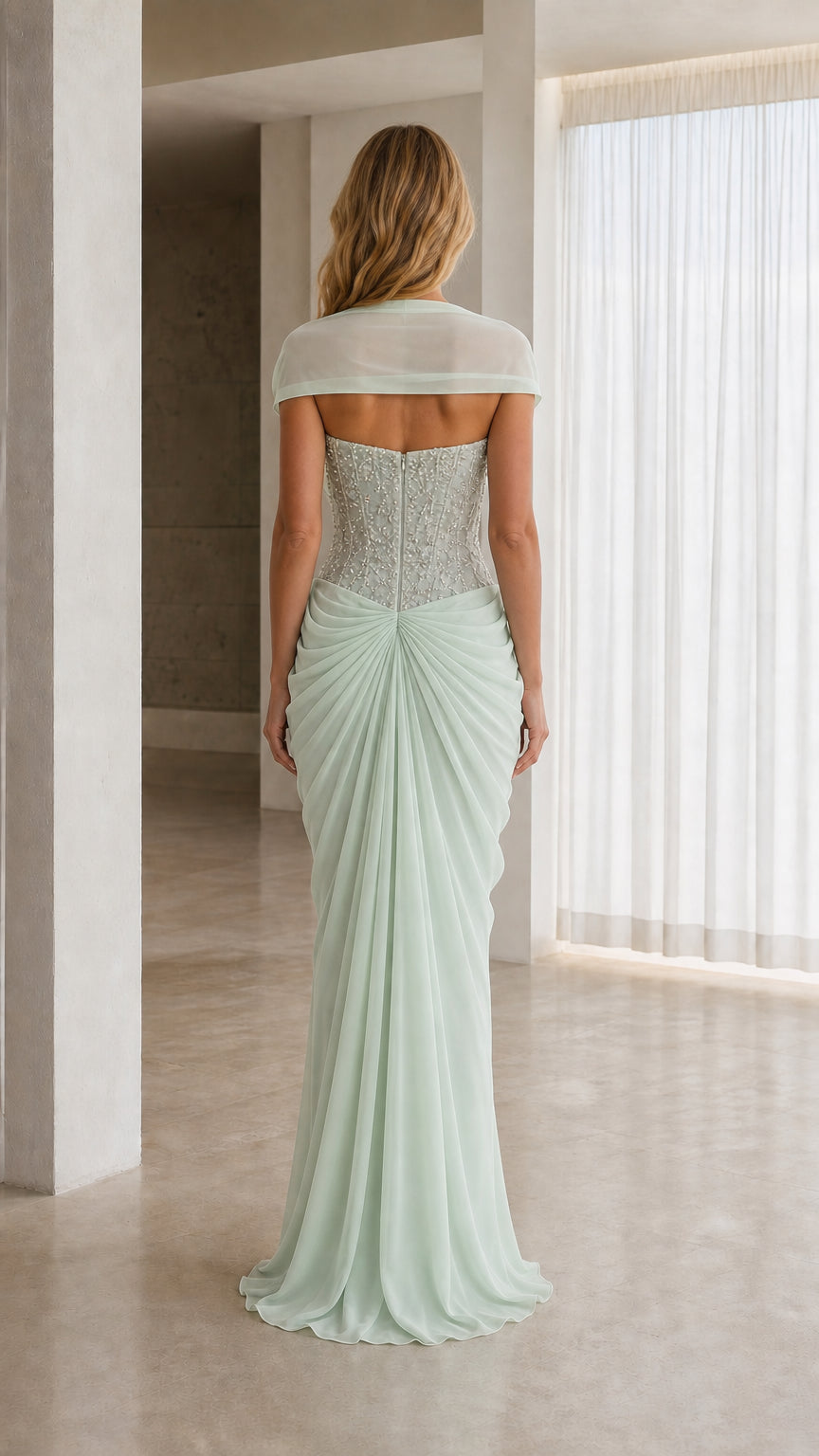Back view of model wearing mint green evening gown with draped shoulder wrap