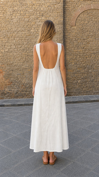 Back view of model showing the low scoop back design of white linen maxi dress