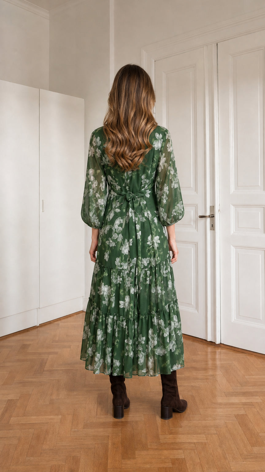 Back view of woman in green floral tiered midi dress