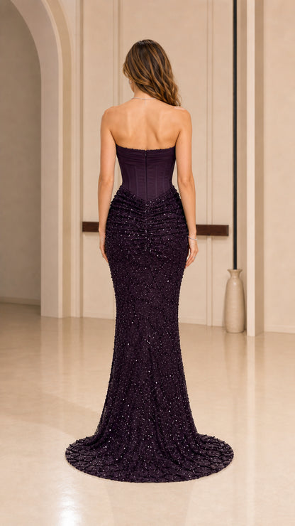 Back view of model showcasing sweeping train of the purple formal dress