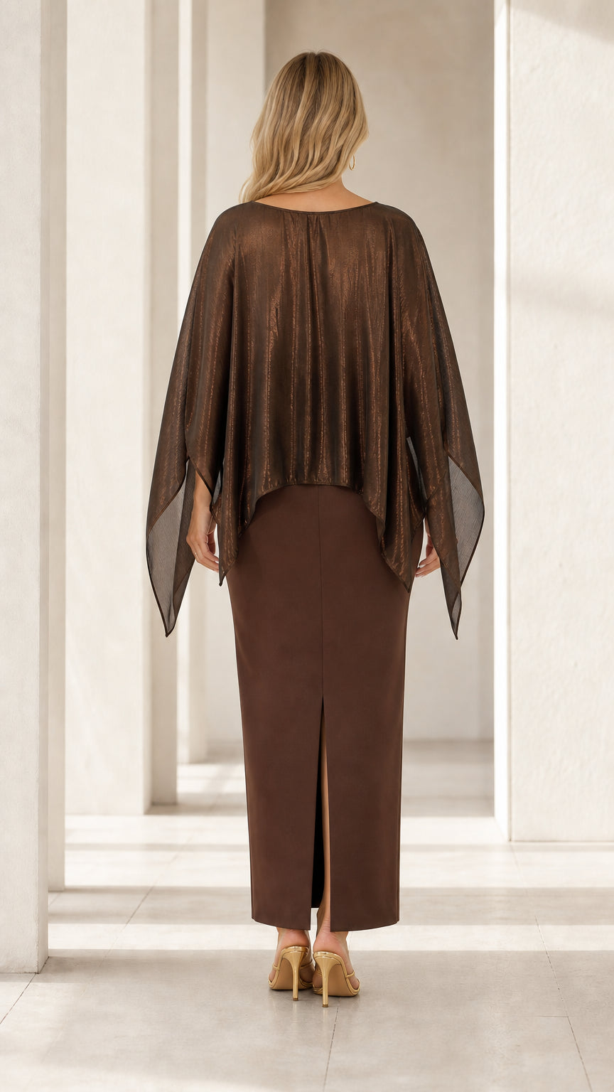 Back view of woman wearing brown capelet maxi gown showing back hem slit