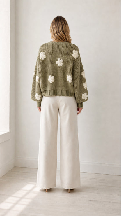 Back view of model wearing sage green chunky knit cardigan with white 3D flower patches