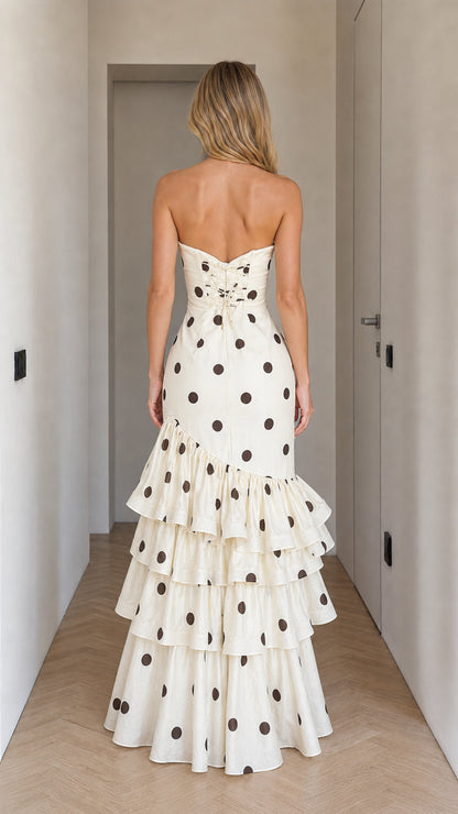 Back view of woman wearing cream polka dot strapless dress
