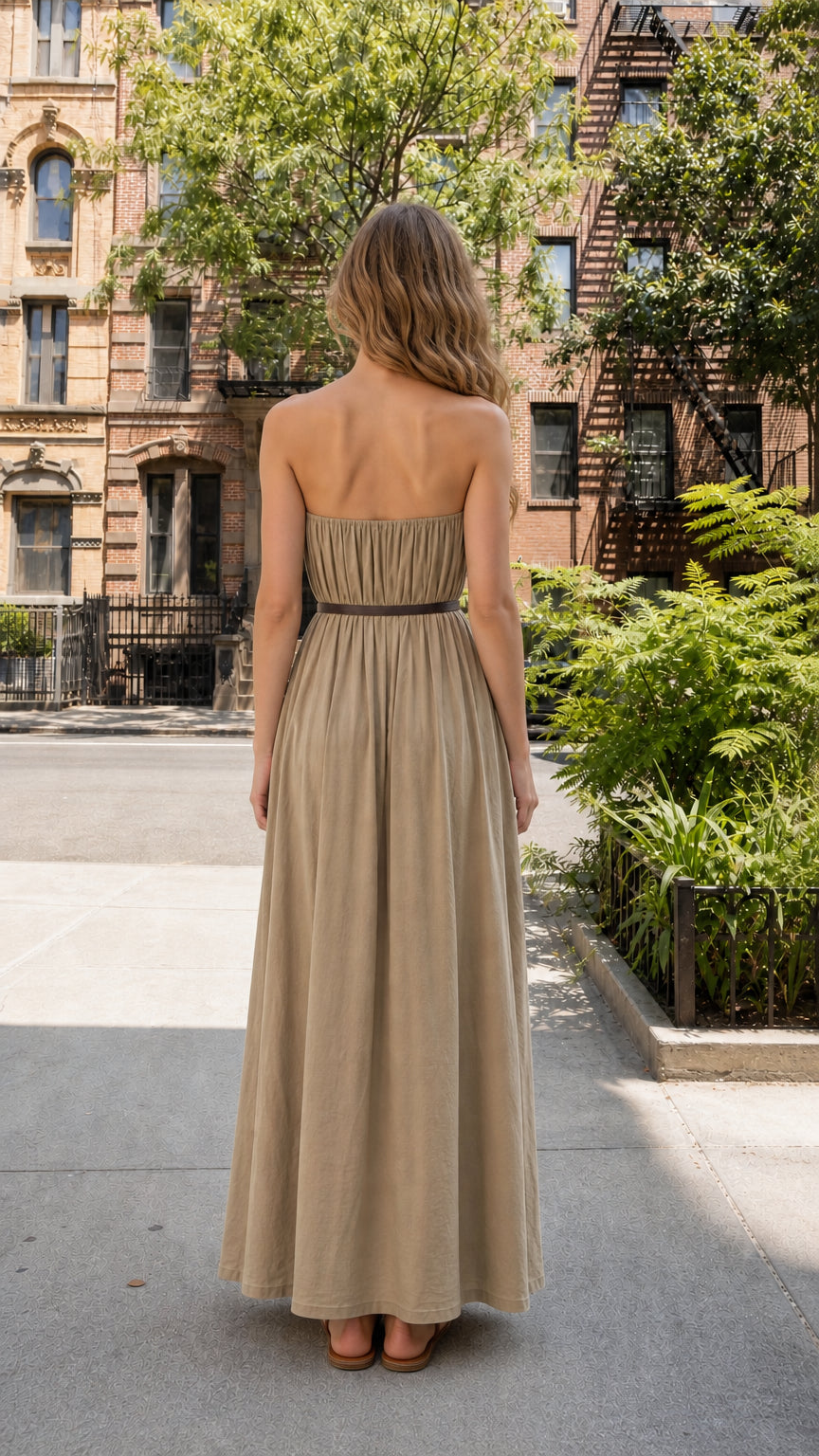 Back view of woman wearing khaki strapless pleated maxi dress
