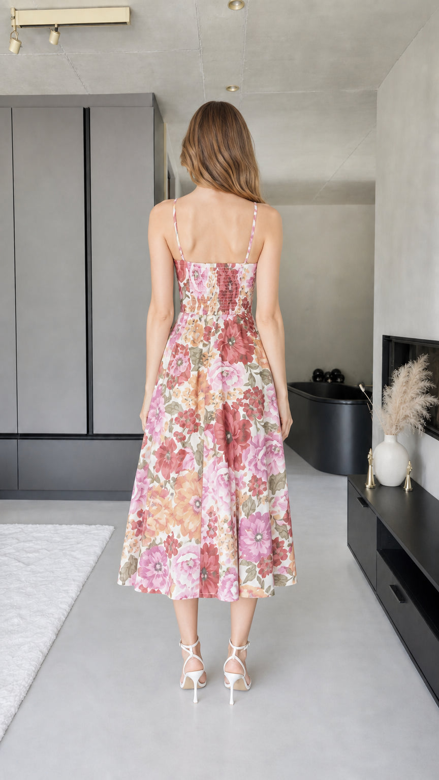 Back view of model showing smocked bodice detail on pink floral dress