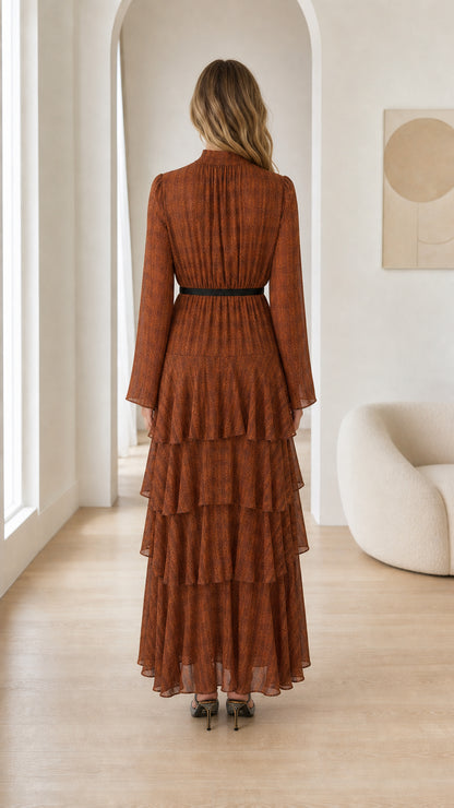 Back view of woman in Rust Brown pleated tiered evening maxi dress