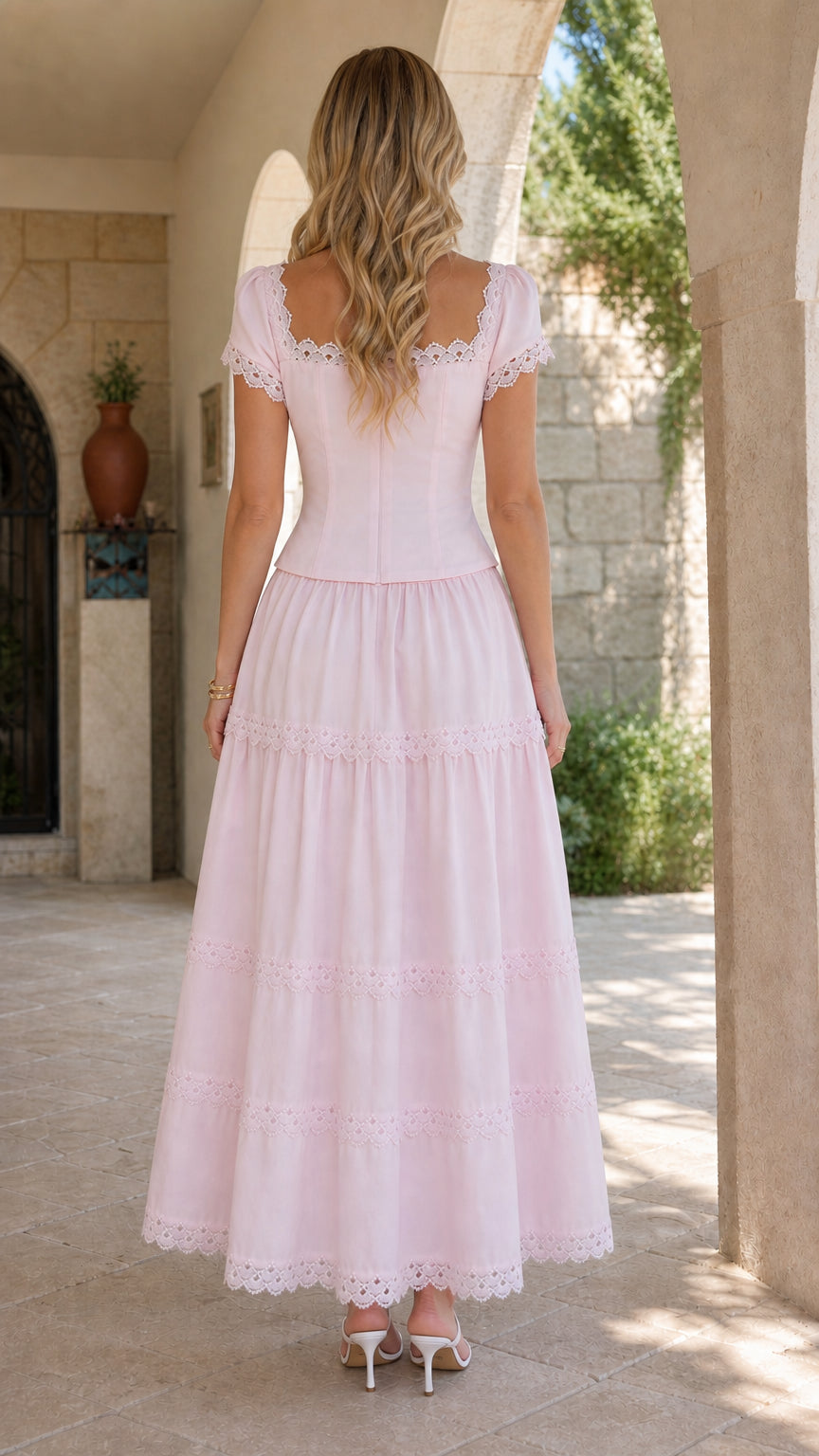 Back full-length view of model wearing a blush pink tiered maxi dress with square back neckline