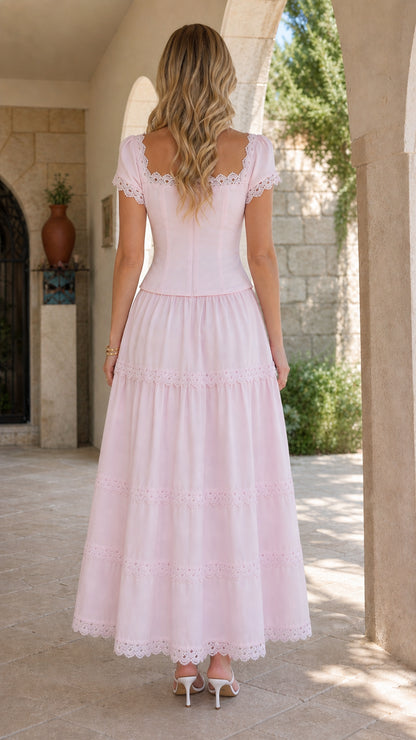 Back full-length view of model wearing a blush pink tiered maxi dress with square back neckline
