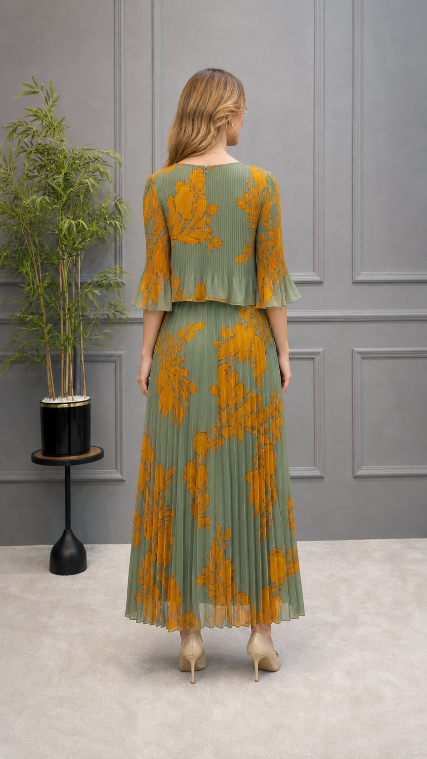 Back view of model wearing sage green floral pleated maxi dress with overlay bodice