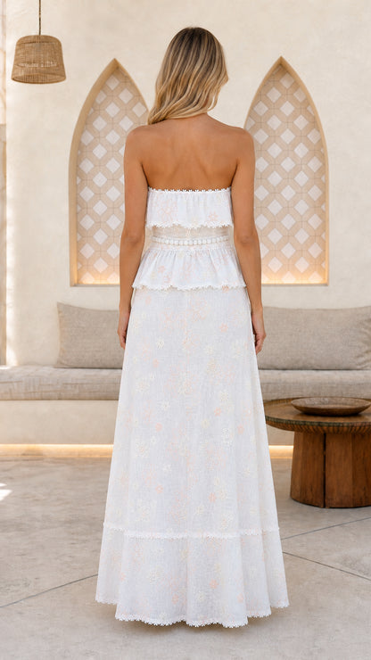 Back view of woman wearing white strapless maxi dress