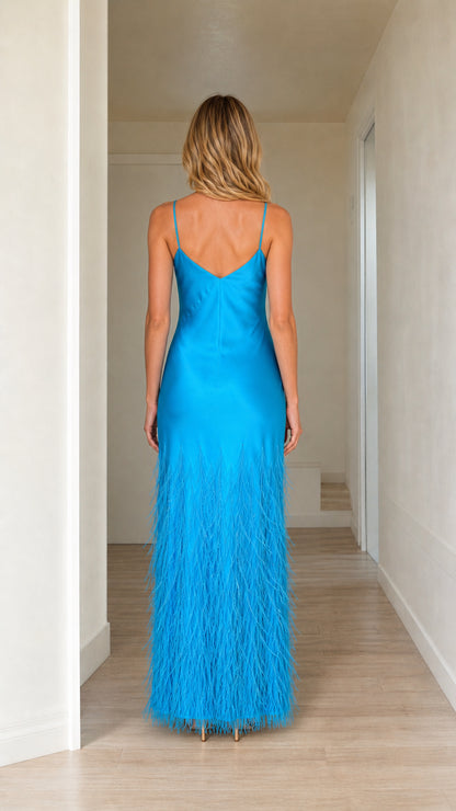 Back view of woman in blue satin slip dress with feather hem