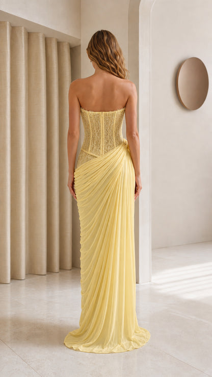 Model wearing yellow strapless evening gown back view