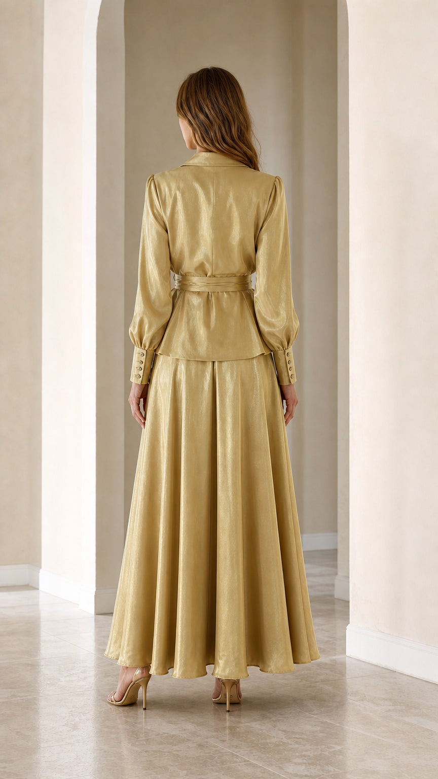Back view of woman wearing Champagne Gold satin wrap blazer top and flowing maxi skirt