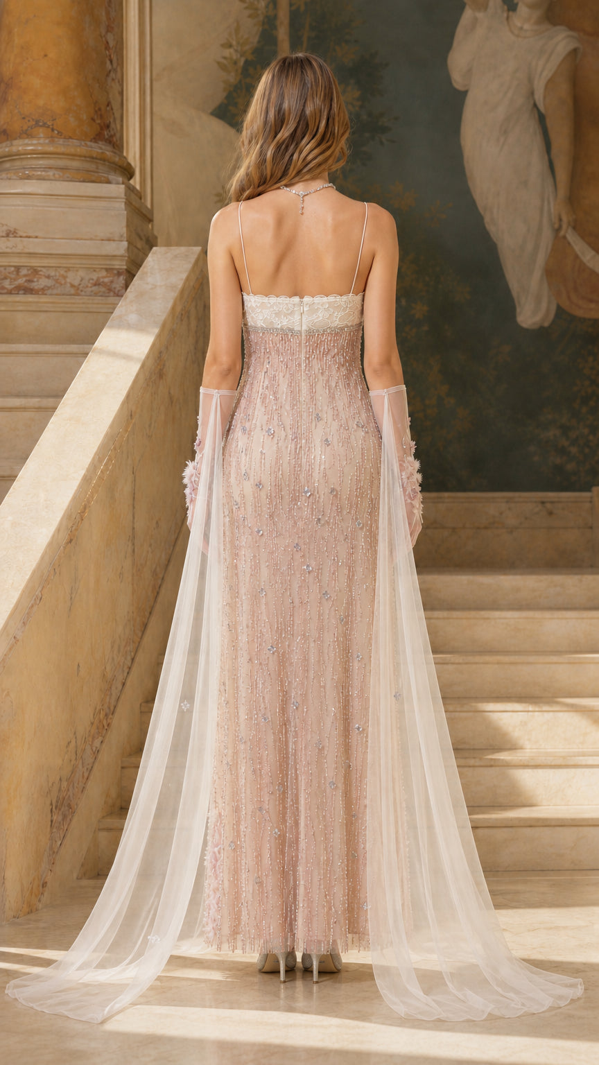 Back view showing sheer flowing cape on blush pink dress