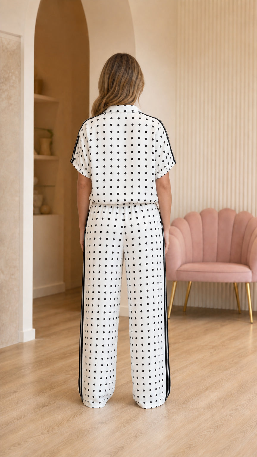 Back view of woman wearing polka dot top and matching trousers