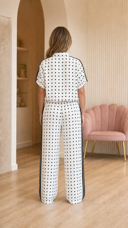Back view of woman wearing polka dot top and matching trousers