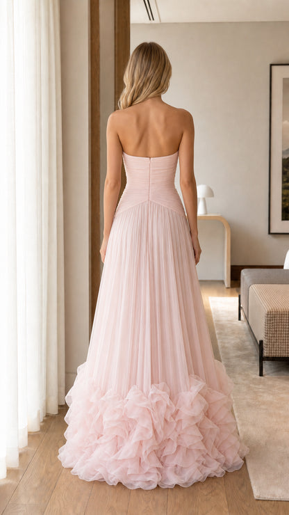 Back view of model in Blush Pink strapless formal dress with pleated skirt