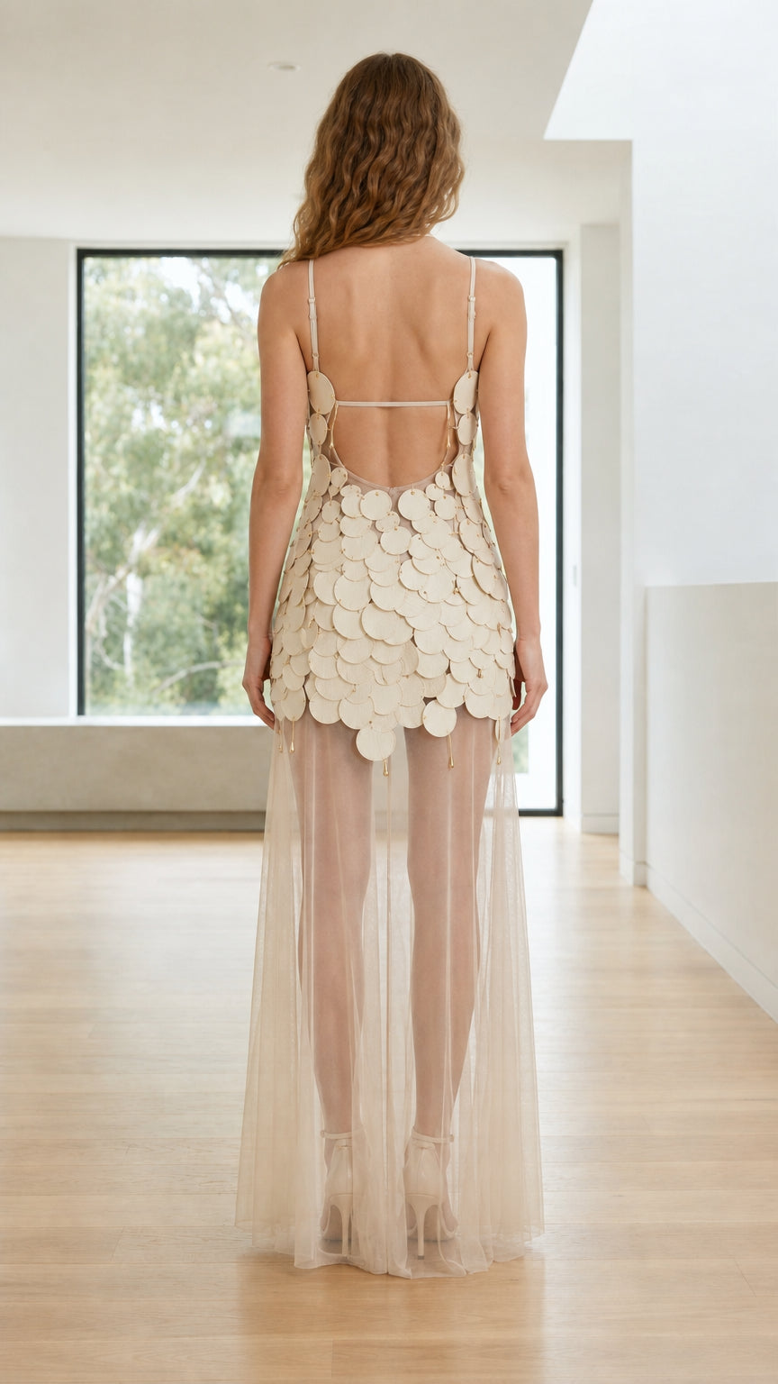 Back view of beige dress showing open back and delicate straps