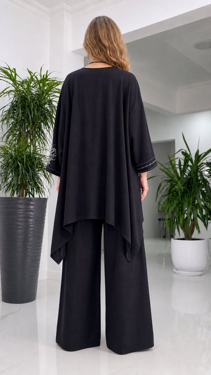 Back view of woman in black tunic and trousers