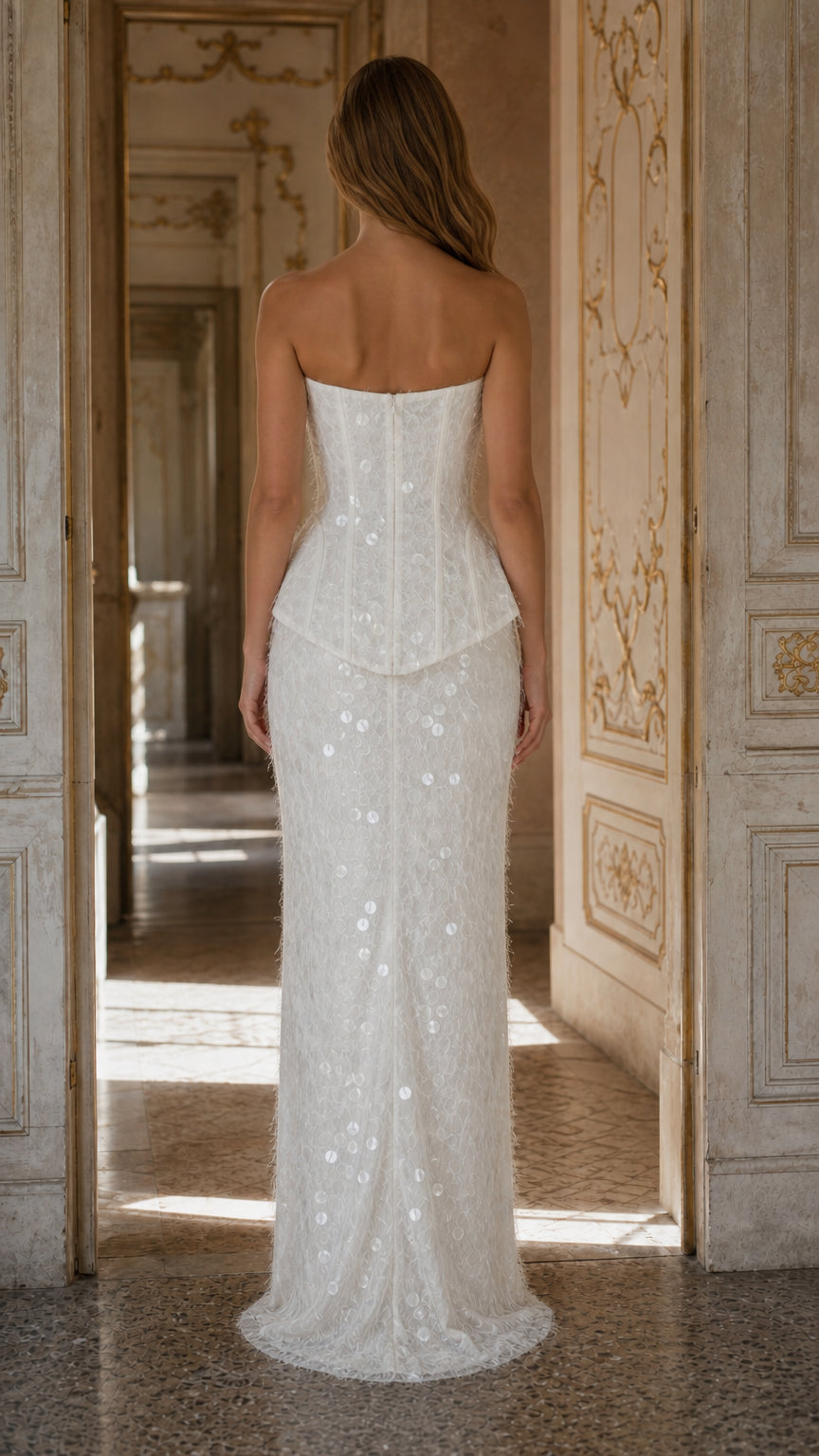Back view of model wearing white strapless corset evening dress with peplum detail
