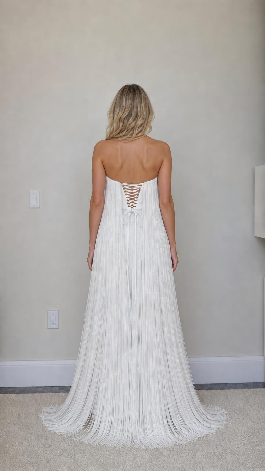 Back view showing lace-up corset detail on white fringe dress
