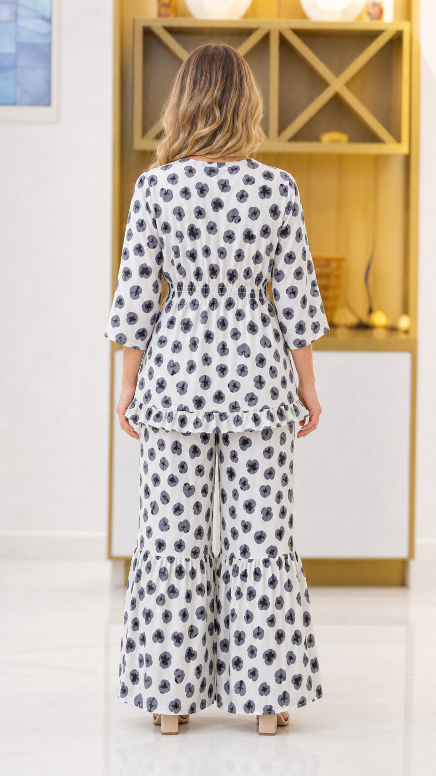 Back view of woman wearing white floral matching set showing fit of smocked waist and trousers