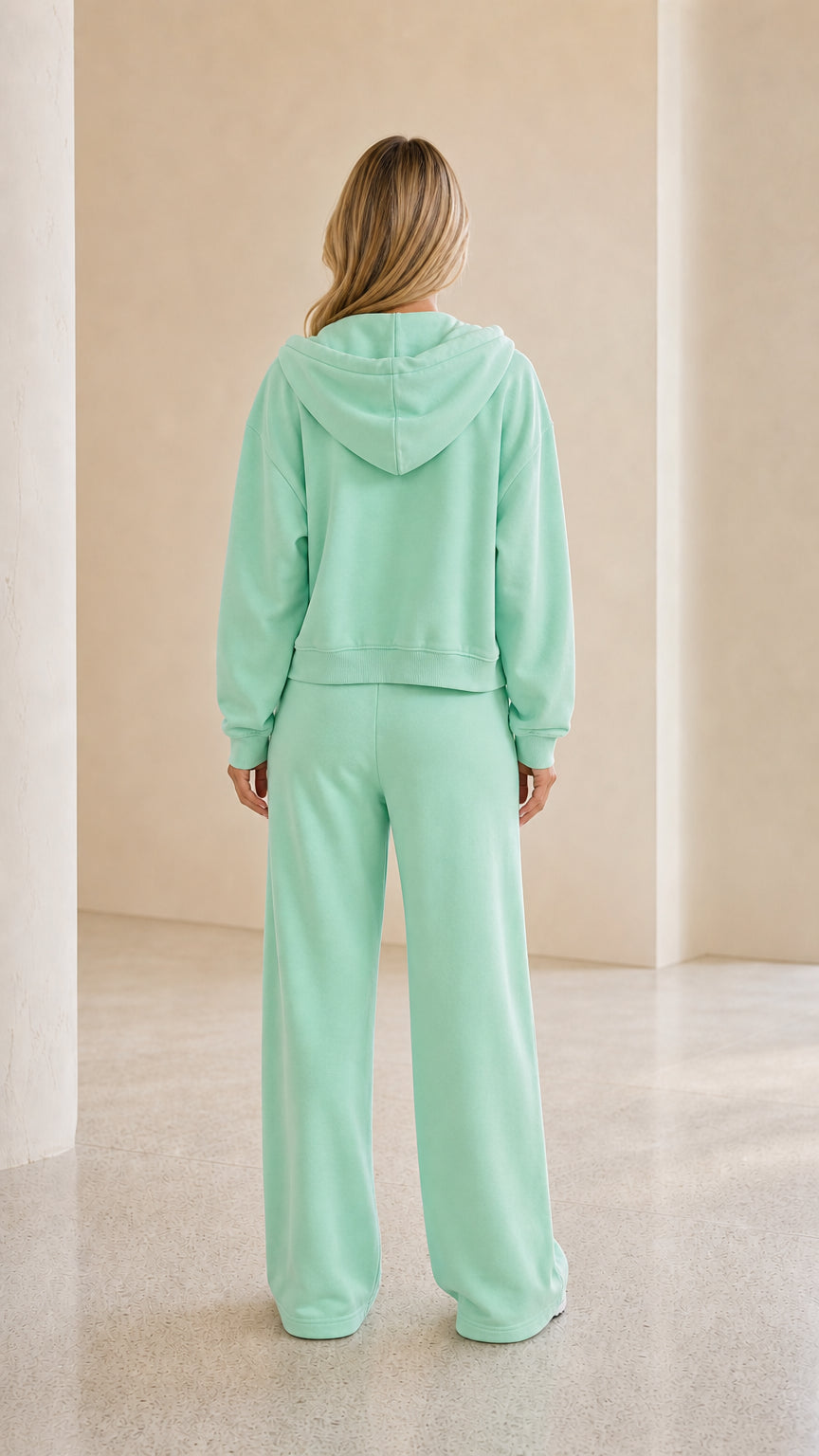 Model wearing mint green tracksuit back view