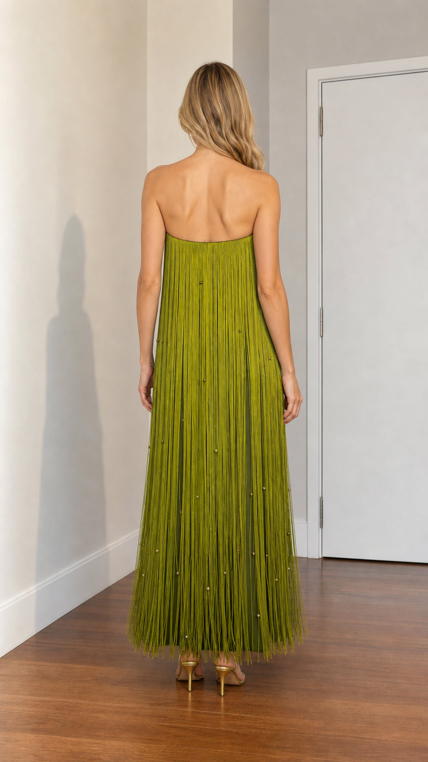 Back view of woman wearing olive green strapless fringe gown