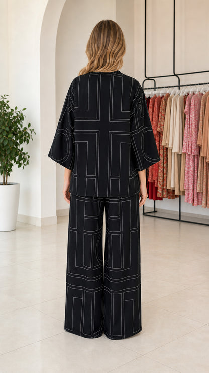 Back view of model wearing black loose-fit geometric print pant set