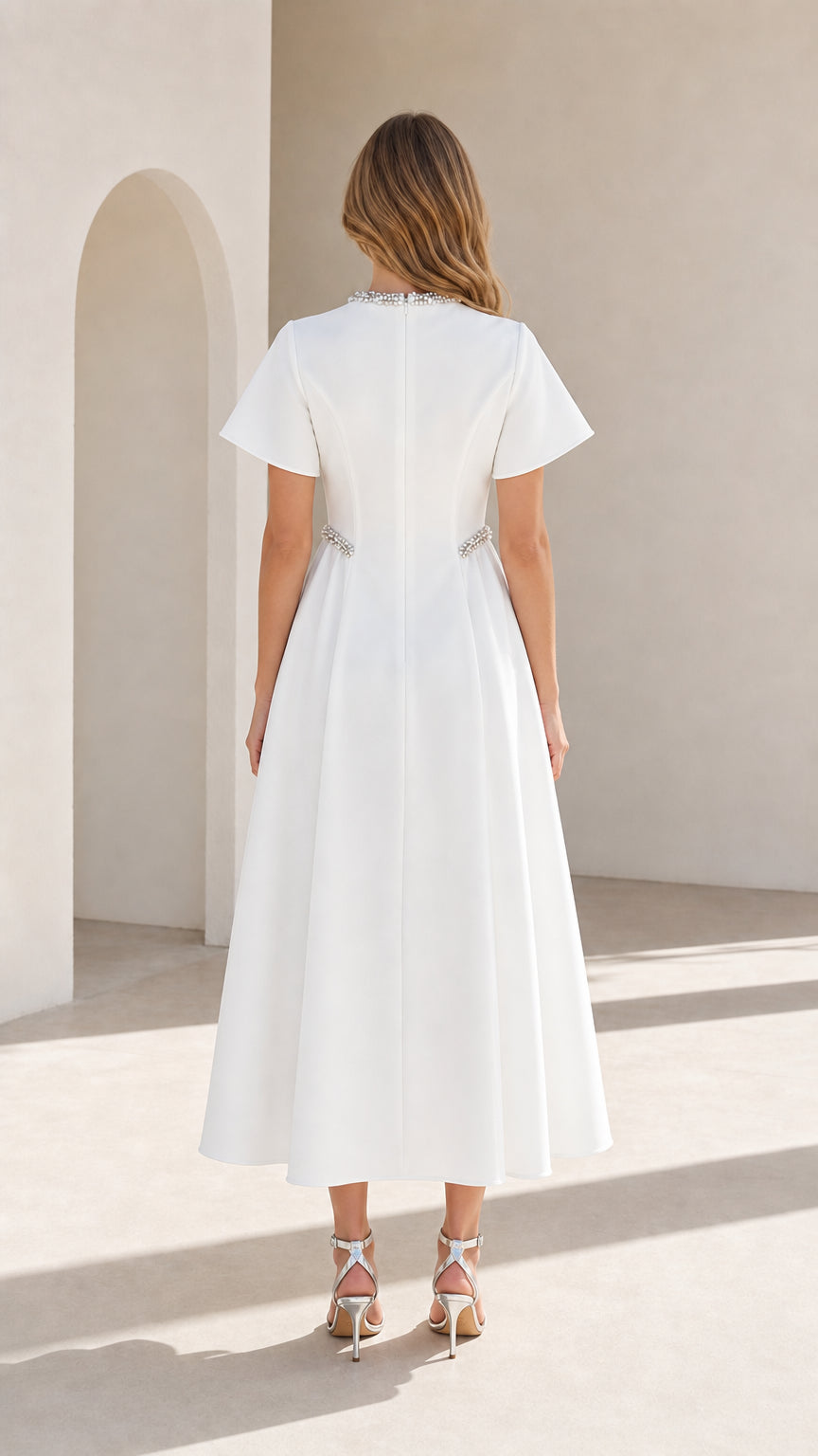 Back view of woman wearing white A-line midi dress showing clean tailored back