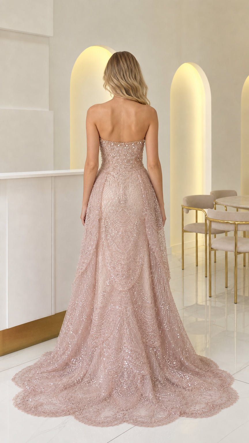Back view of dusty rose strapless evening gown with cascading train