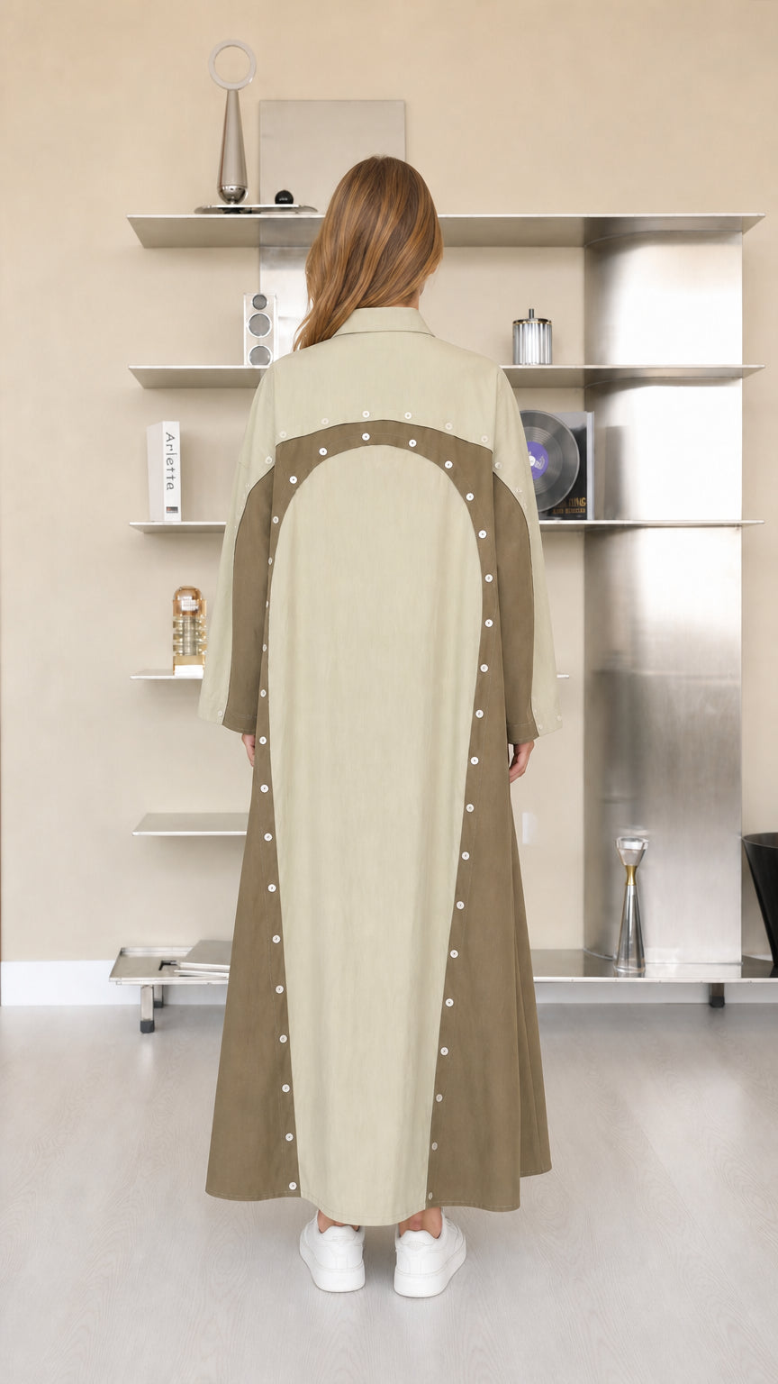 Back view of sage green two-tone maxi dress showing curved panel and button accents