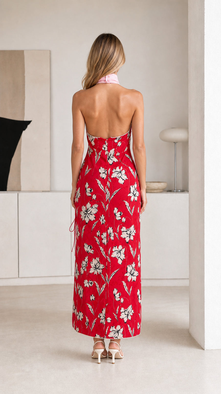 Back view of woman in red floral maxi dress showing open back
