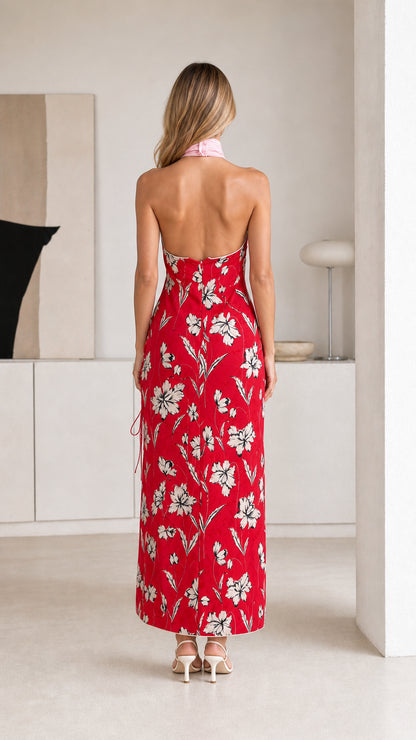 Back view of woman in red floral maxi dress showing open back