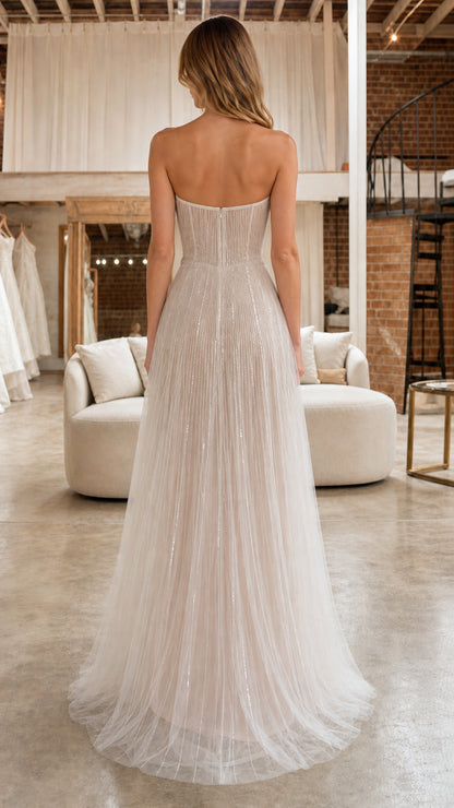 Back view of model showing strapless bodice and flowing tulle skirt in ivory
