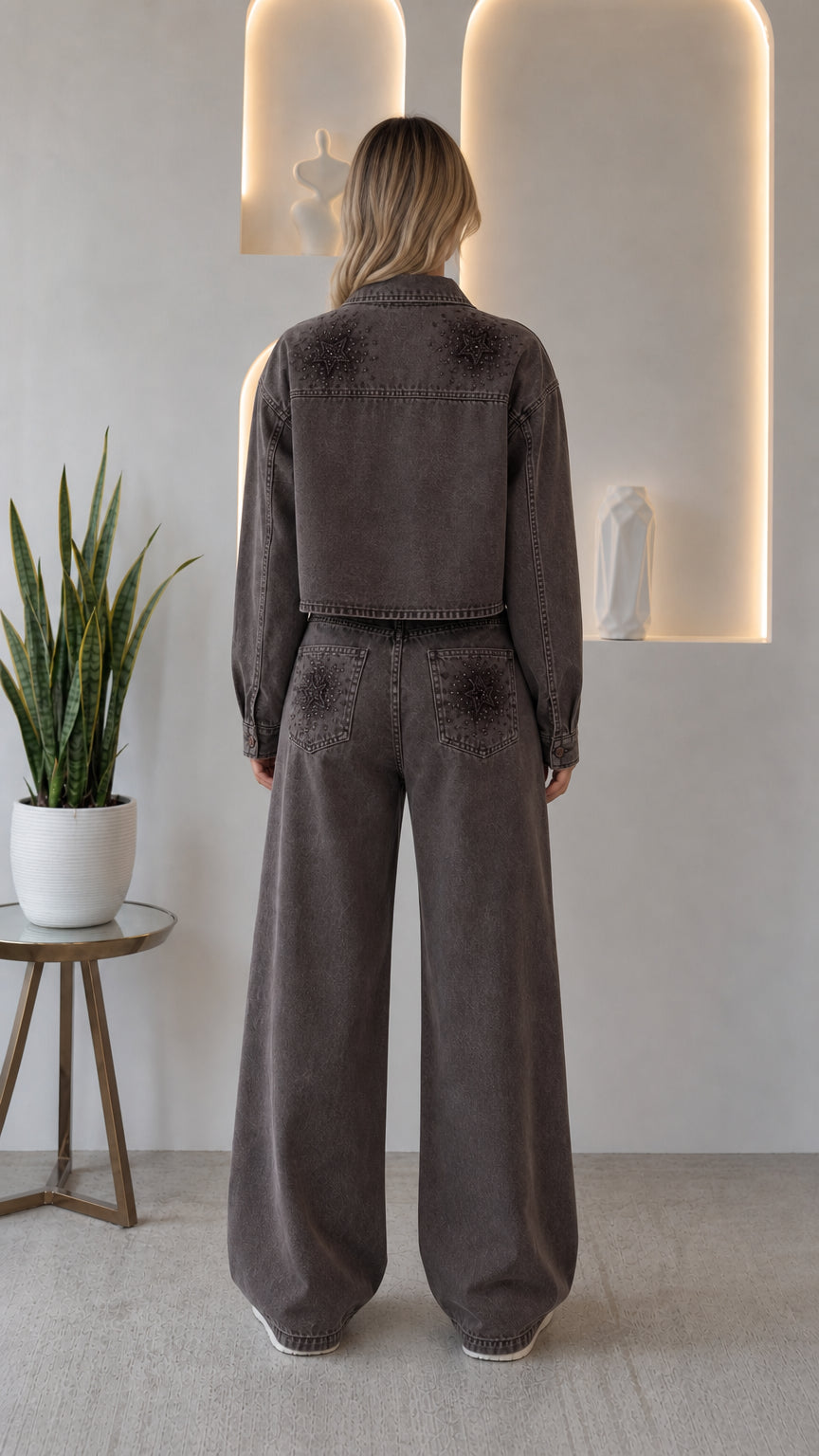 Back view of woman wearing washed grey star studded cropped denim jacket and matching jeans