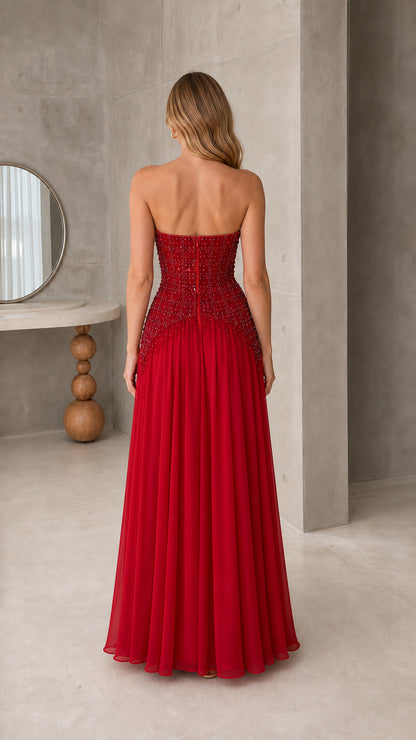 Back view of model wearing strapless ruby red maxi formal gown