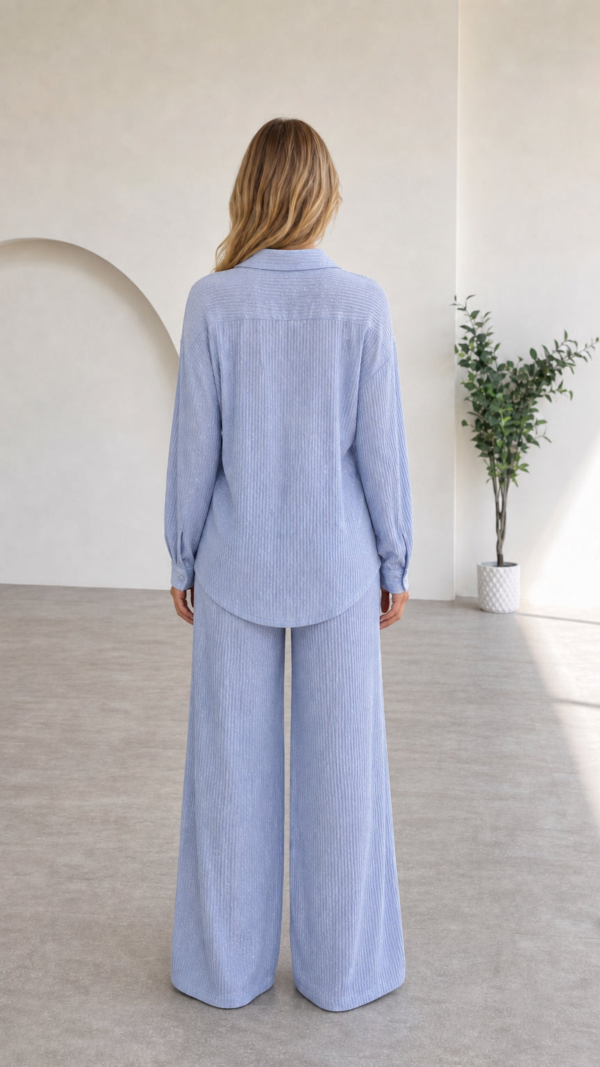 Back view of light blue long-sleeve shirt and wide leg trousers
